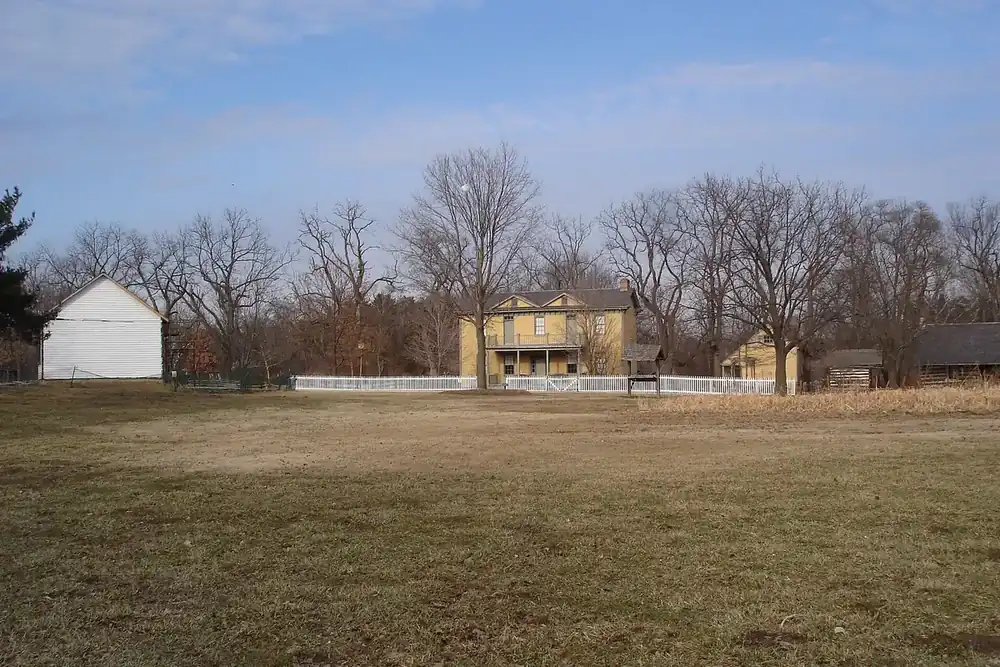 Historic farmhouse and outbuildings across a winter lawn at Faust Park in Chesterfield, Missouri