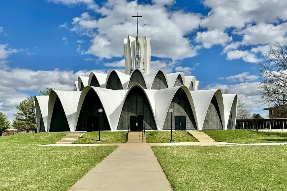 The white arched Priory Chapel at St. Louis Abbey across a lawn in Creve Coeur