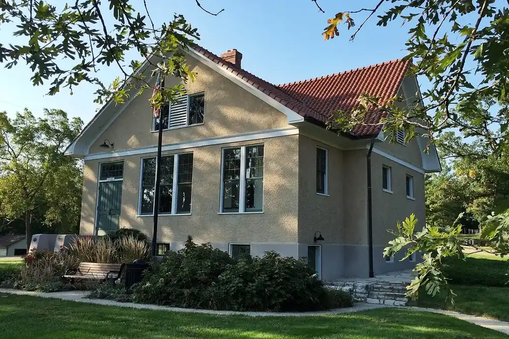 The restored Pond School building beside a lawn and oak trees in Wildwood, Missouri